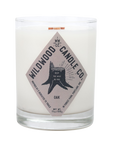 A clear glass jar candle with white wax and a diamond-shaped beige label reading Oak by Wildwood Candle Co., shown on a plain white background.