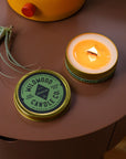 Lit Arboretum travel candle made by Wildwood Candle Co. on a side table
